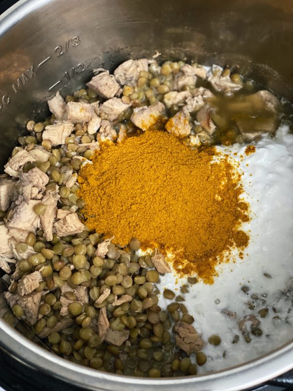 Instant pot filled with coconut curry lentil soup ingredients
