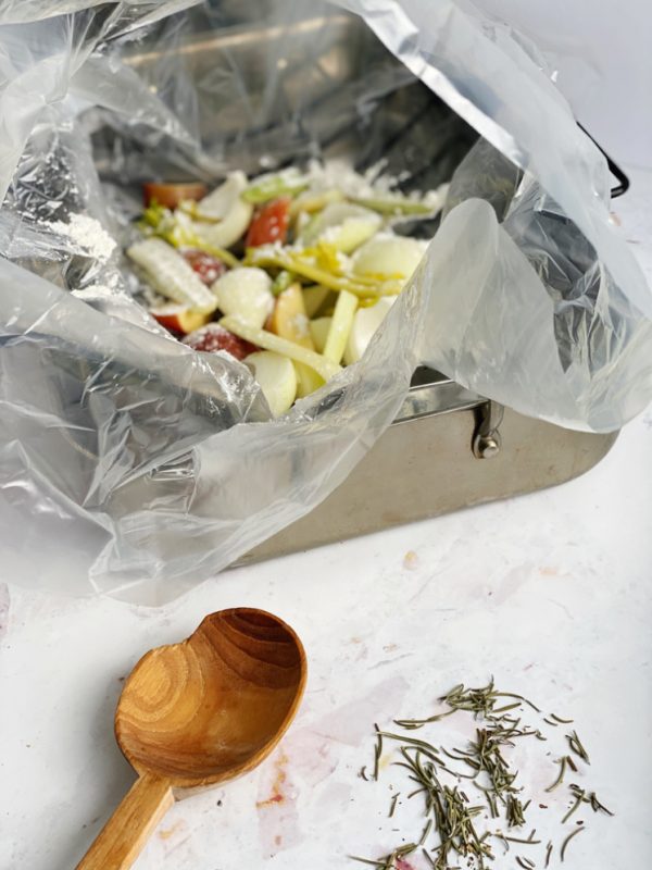roasting pan with onions and apples in oven roasting bag